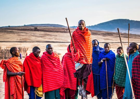 Photo of Group of Men Wearing Assorted Scarves Holding Sticks