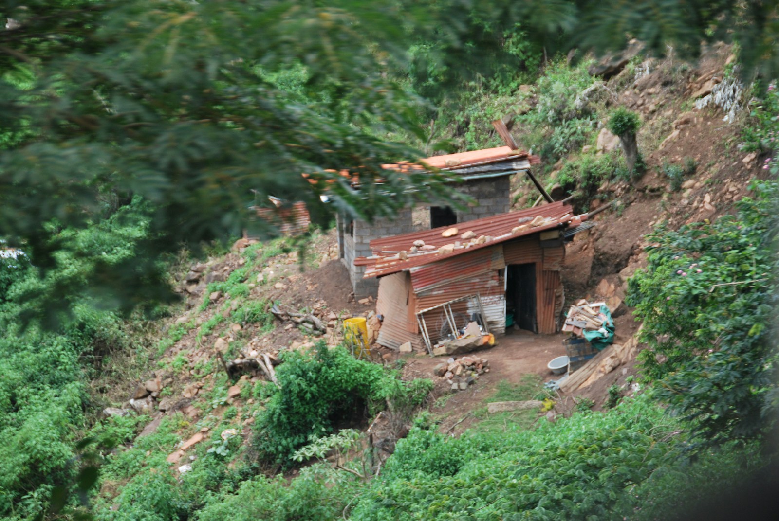 a small building sitting on top of a lush green hillside