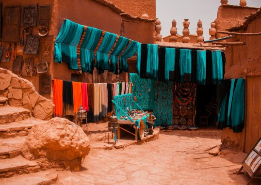 assorted-color textiles hanged beside concrete buildings